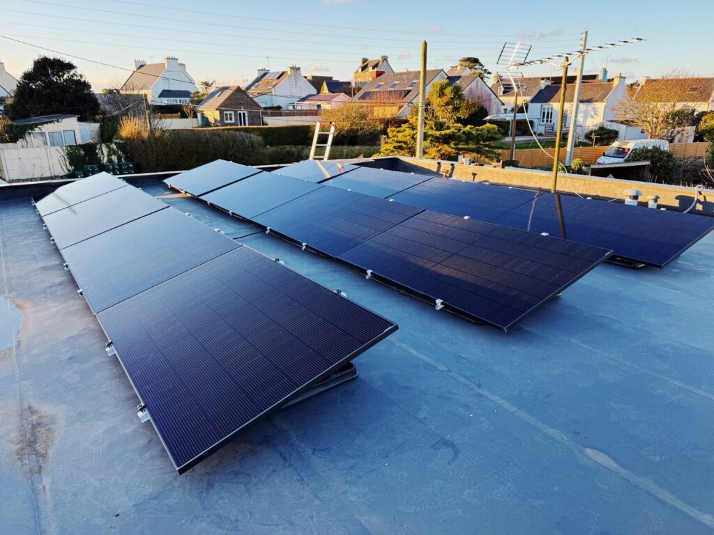 Installation photovoltaïque en toiture plate avec grue en arrière-plan en Bretagne