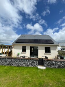 Maison individuelle avec panneaux solaires en toiture et jardin en Bretagne